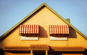 Close up of a Spanish house in Madrid with red and white striped awnings under a clear sky